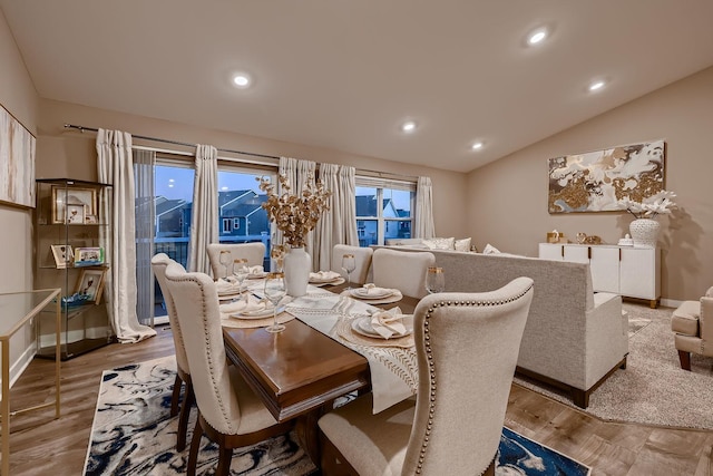 dining room featuring vaulted ceiling and hardwood / wood-style flooring