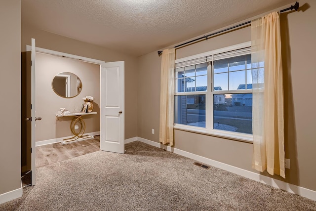 unfurnished bedroom featuring carpet and a textured ceiling