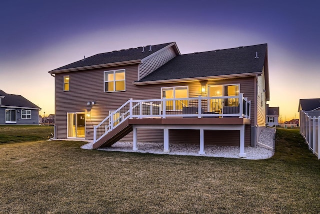 back house at dusk featuring a deck and a yard