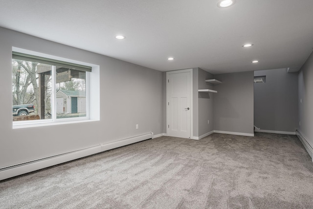 unfurnished bedroom featuring a baseboard heating unit, light colored carpet, and a closet