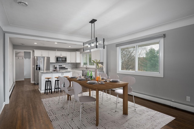 dining space featuring dark hardwood / wood-style flooring, sink, and baseboard heating