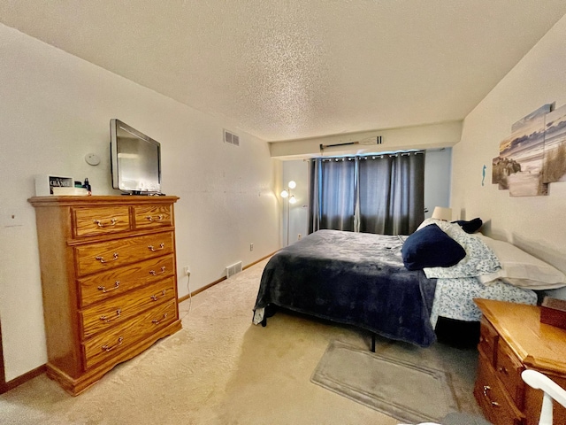 bedroom featuring a textured ceiling and light carpet