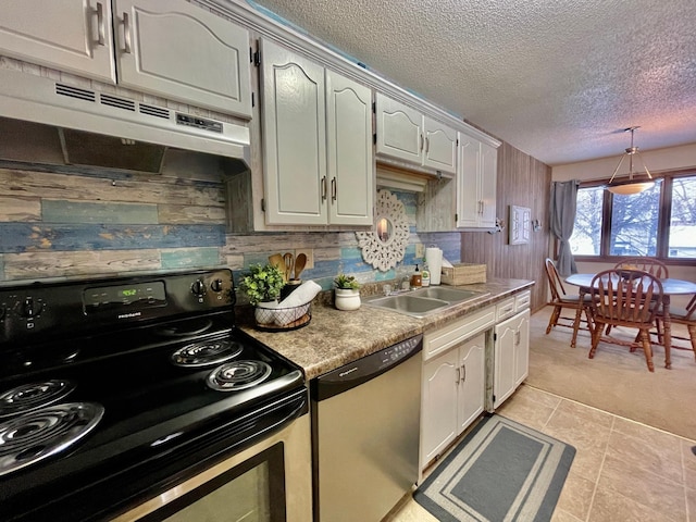 kitchen with stainless steel dishwasher, sink, wooden walls, and black electric range