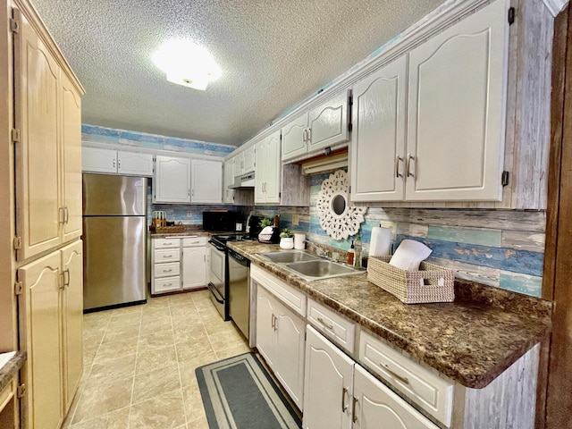 kitchen with sink, decorative backsplash, light tile patterned floors, a textured ceiling, and appliances with stainless steel finishes