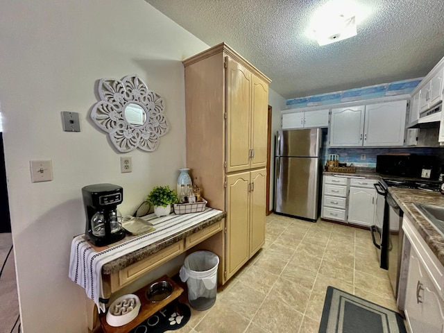 kitchen featuring white cabinets, backsplash, a textured ceiling, light tile patterned floors, and appliances with stainless steel finishes