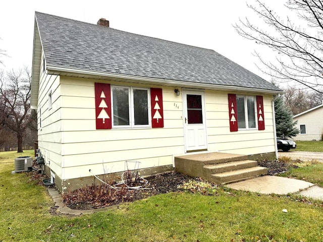 view of front of property with a front lawn and cooling unit