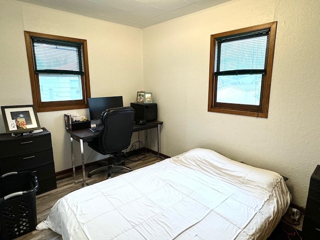 bedroom featuring multiple windows, dark wood-type flooring, and ornamental molding