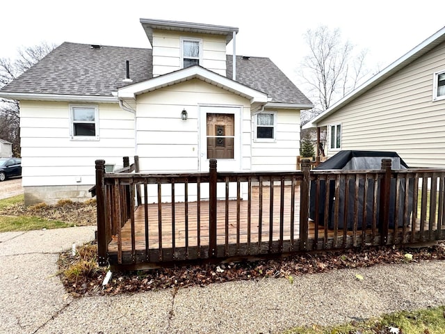 rear view of house featuring a wooden deck