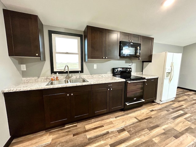 kitchen with black appliances, light hardwood / wood-style floors, dark brown cabinetry, and sink