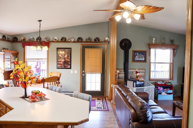 dining area featuring lofted ceiling, ceiling fan with notable chandelier, and a baseboard heating unit