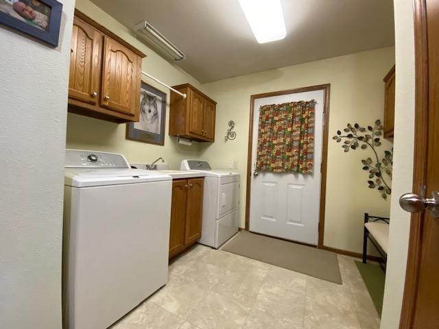 washroom with sink, washer and clothes dryer, and cabinets