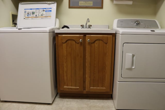 laundry room featuring sink, cabinets, washer and clothes dryer, and light tile patterned floors