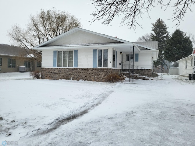 snow covered house with central AC unit