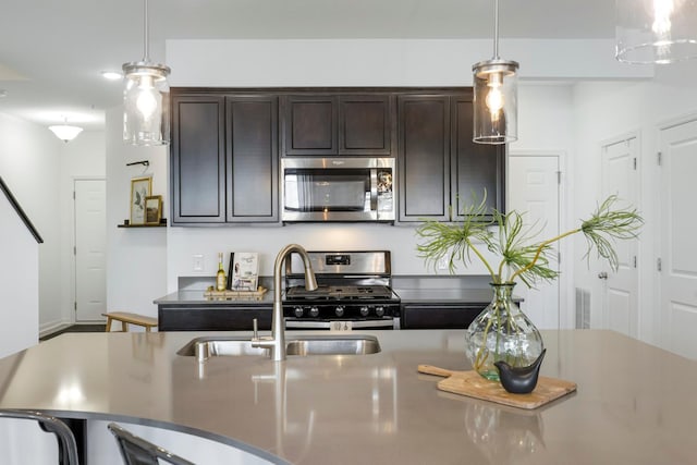 kitchen featuring sink, decorative light fixtures, dark brown cabinets, and stainless steel appliances