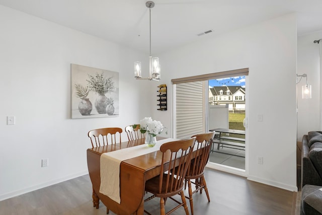 dining room with an inviting chandelier and dark hardwood / wood-style flooring