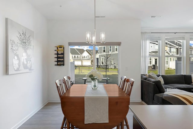 dining area featuring hardwood / wood-style flooring and a notable chandelier