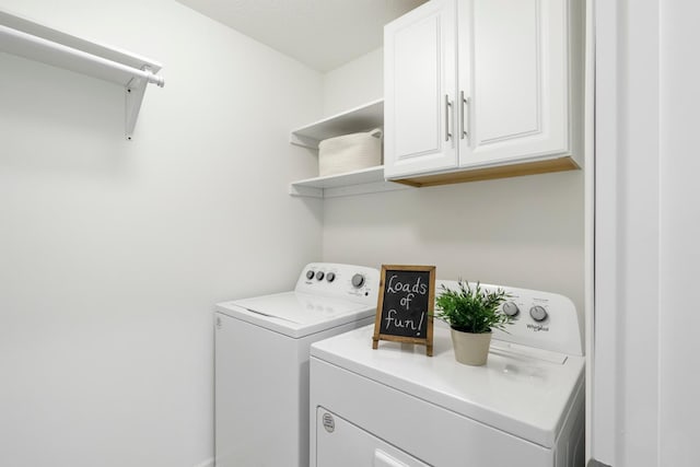 laundry area with washing machine and dryer and cabinets