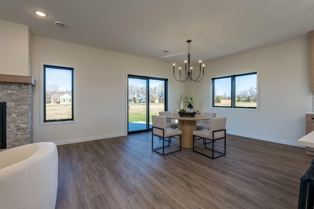 dining room with a fireplace, dark hardwood / wood-style floors, and a notable chandelier