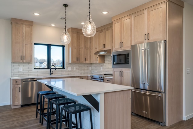 kitchen featuring sink, light brown cabinetry, appliances with stainless steel finishes, a kitchen island, and dark hardwood / wood-style flooring