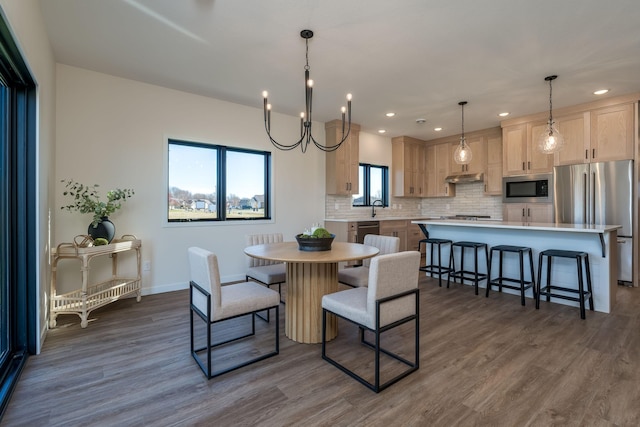 dining area featuring dark hardwood / wood-style flooring, an inviting chandelier, and sink