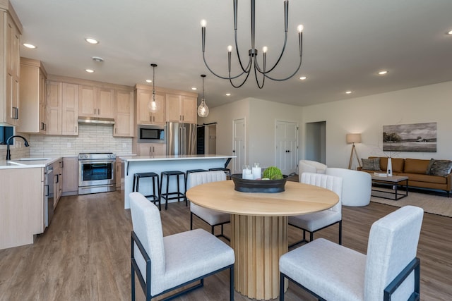 dining space featuring light hardwood / wood-style floors, an inviting chandelier, and sink