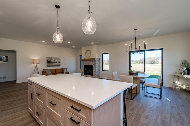 kitchen with pendant lighting, light brown cabinets, dark wood-type flooring, and a breakfast bar