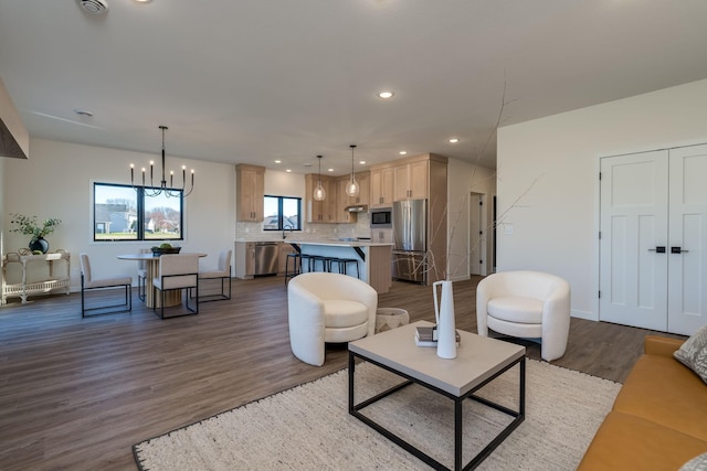 living room with a chandelier, dark hardwood / wood-style flooring, plenty of natural light, and sink