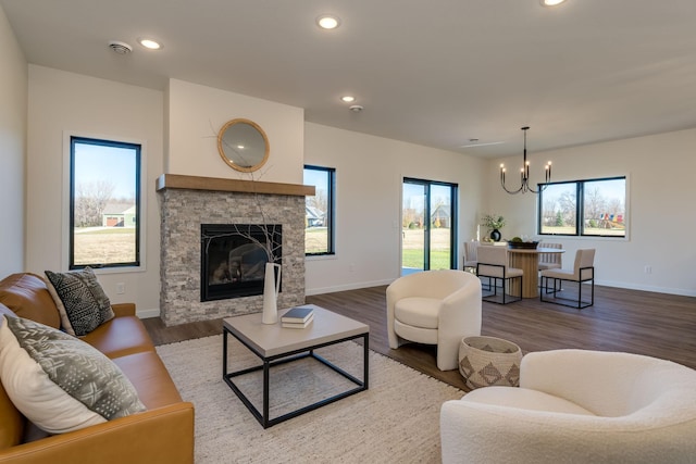 living room featuring a fireplace, wood-type flooring, and a chandelier