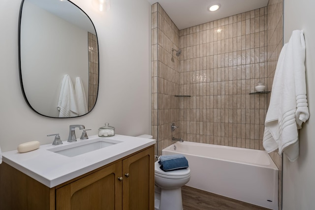 full bathroom with vanity, tiled shower / bath, wood-type flooring, and toilet