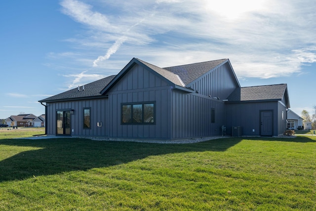 back of property with central air condition unit and a yard