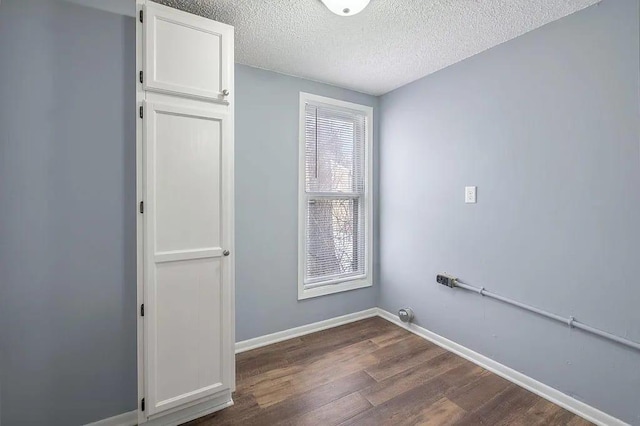 laundry area featuring dark hardwood / wood-style floors and a textured ceiling