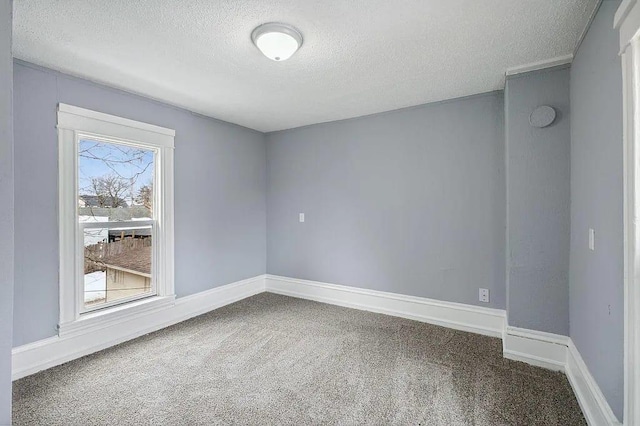 carpeted spare room with a textured ceiling