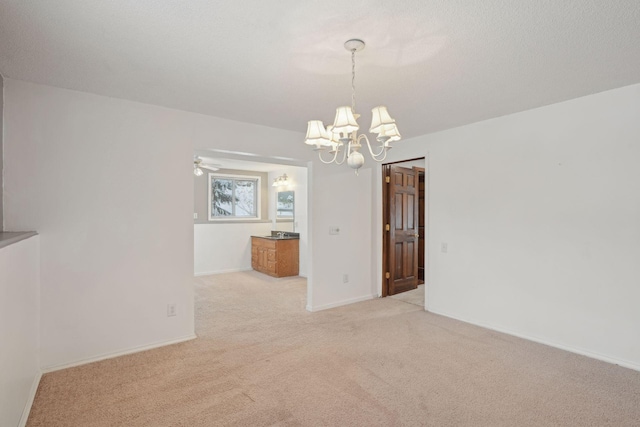 unfurnished dining area with ceiling fan with notable chandelier and light carpet