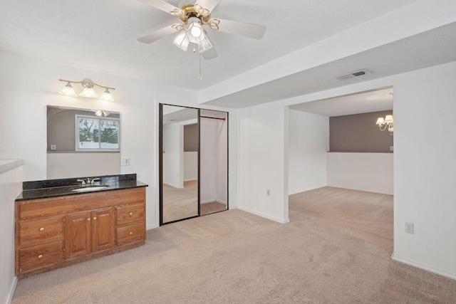 bathroom with vanity and ceiling fan with notable chandelier