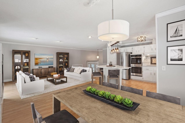 living area with light wood-style floors and crown molding