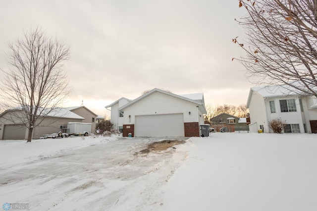1215 18th St N, Moorhead, MN 56560 - view of snowy exterior with an attached garage and brick siding