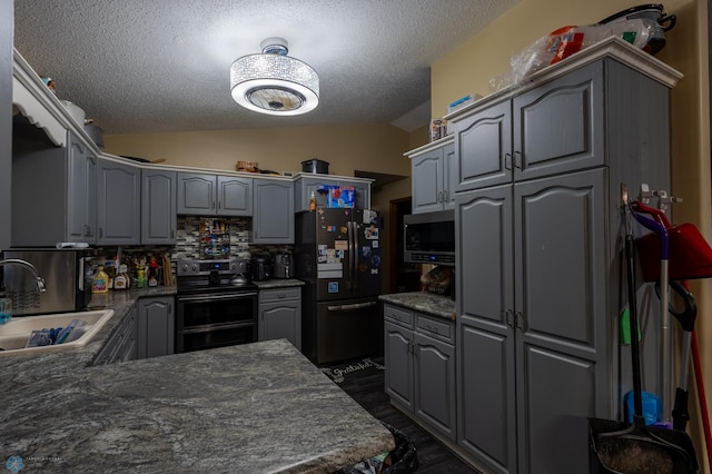 1215 18th St N, Moorhead, MN 56560 - kitchen featuring double oven range, freestanding refrigerator, a sink, vaulted ceiling, and gray cabinetry