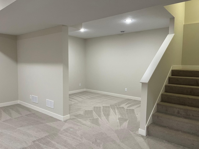 basement featuring light colored carpet