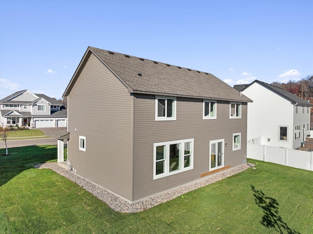 rear view of property featuring a lawn