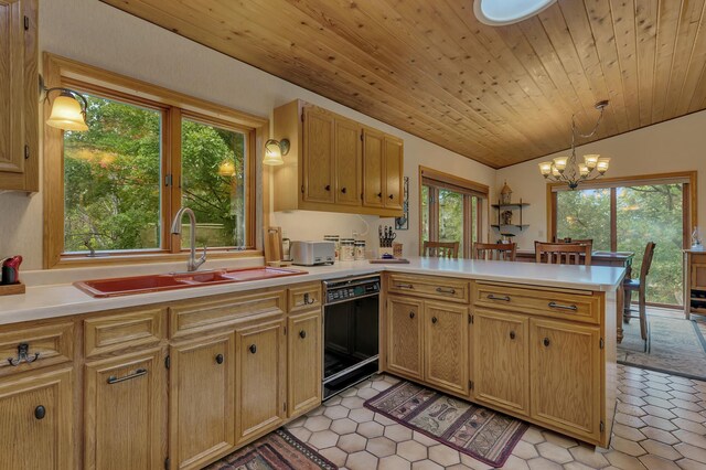 kitchen with dishwasher, lofted ceiling, an inviting chandelier, decorative light fixtures, and kitchen peninsula