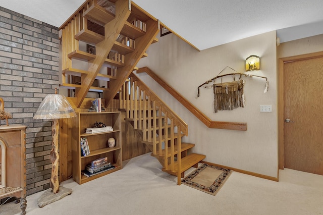 staircase with carpet flooring and a textured ceiling