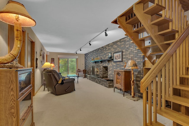 living room with a wood stove, light carpet, brick wall, and track lighting