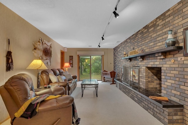 living room featuring brick wall, track lighting, and a brick fireplace