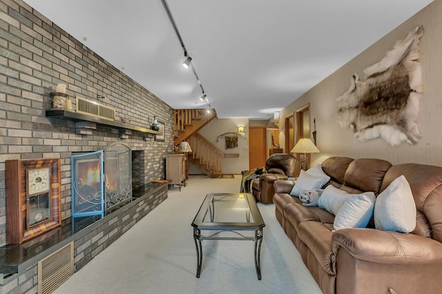 living room with light carpet, rail lighting, and brick wall