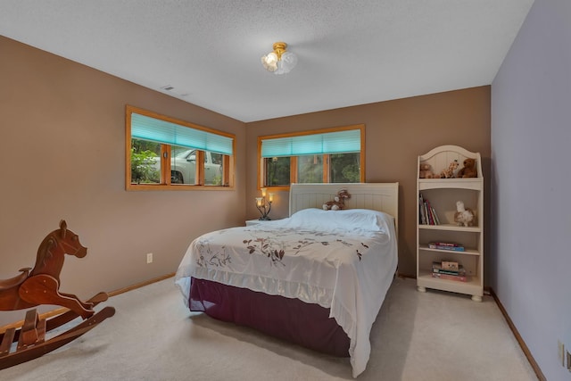 bedroom featuring a textured ceiling and light carpet