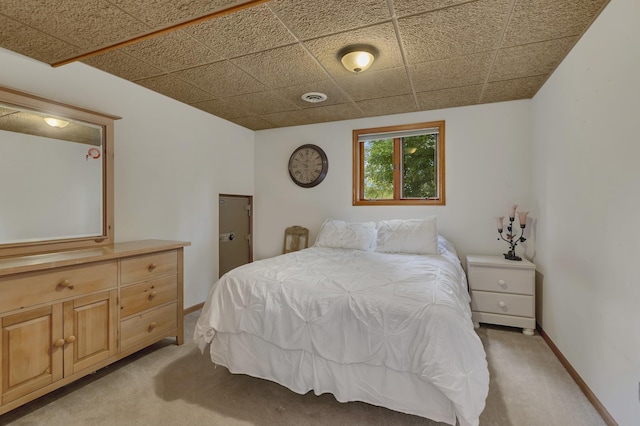 carpeted bedroom featuring a paneled ceiling