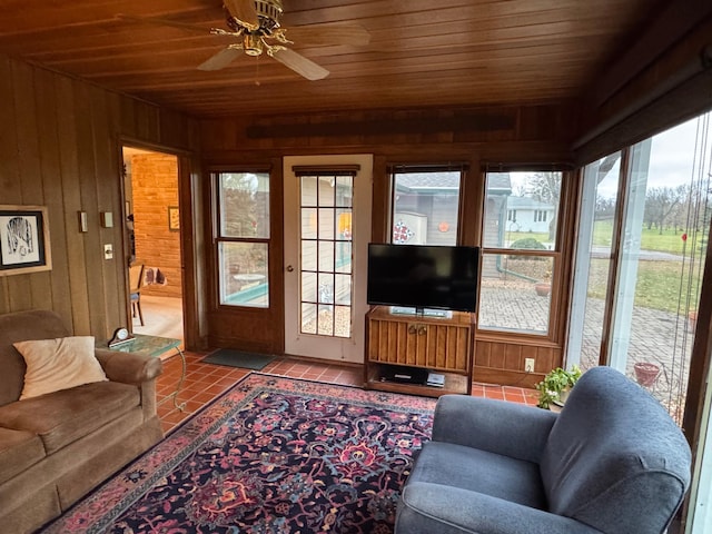 tiled living room featuring wooden walls, ceiling fan, and wooden ceiling