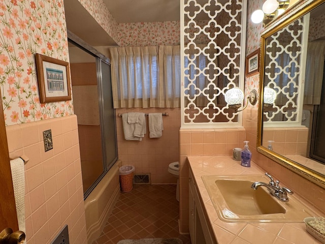 full bathroom featuring tile patterned floors, vanity, toilet, and tile walls