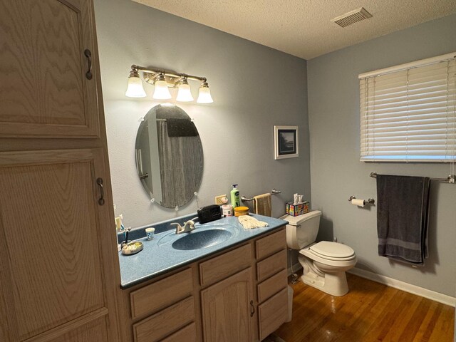 bathroom featuring hardwood / wood-style floors, vanity, a textured ceiling, and toilet