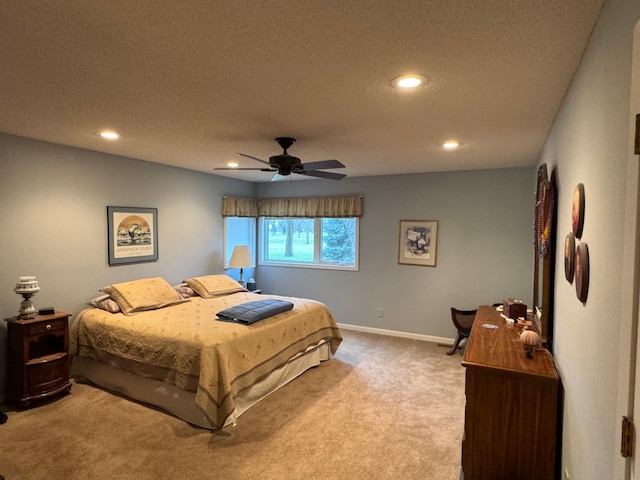 bedroom with ceiling fan, carpet floors, and a textured ceiling